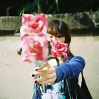 寻找一个黄头发女生拿花挡住脸的qq头像
