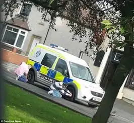 胆大包天英两男子光天化日放警车轮胎气
