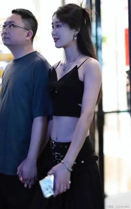 一位成熟稳重的男子和一位青春靓丽的女子手牵手出现在街头

