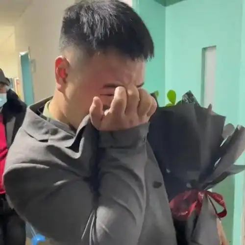 感动男子身穿西装手捧鲜花含泪迎接刨腹产的妻子
