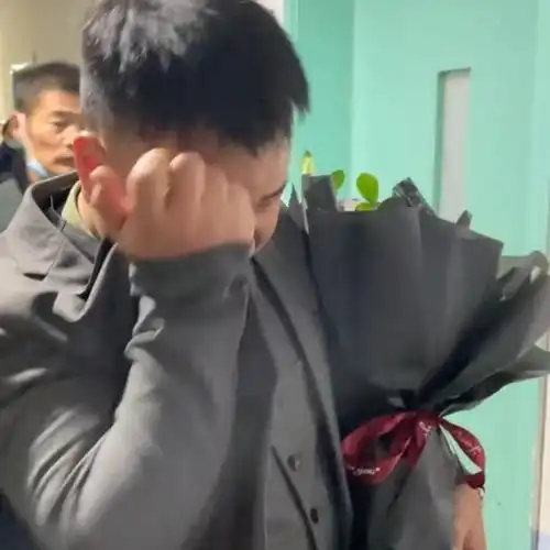 感动男子身穿西装手捧鲜花含泪迎接刨腹产的妻子
