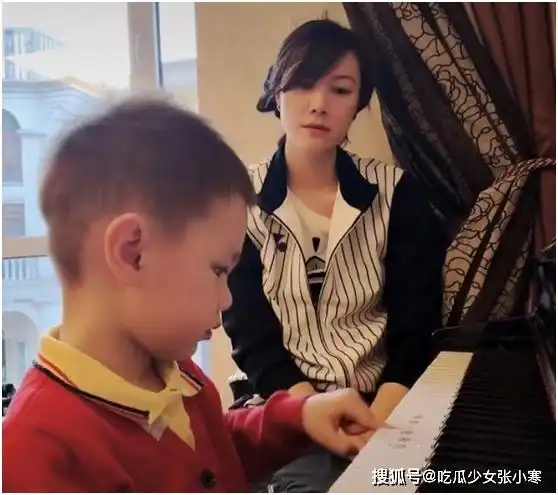 林丹儿子弹钢琴,大眼睛嘟嘟脸萌态十足,妻子表情严肃如监考老师
