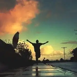 一个小男孩在一条马路上奔跑的背影穿着黑色的衣服
